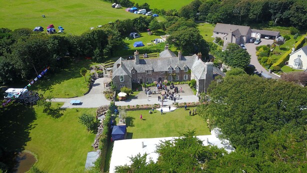 A large estate with a central building surrounded by lush green fields and a few tents. - Bay Cottage, a section of Ebbingford Manor, 850 yr old manor house by beach&town (Bude)
