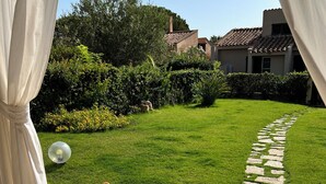 A patio area with a stone pathway leading to a lush green lawn. - Villa with garden just 200 meters from the beautiful beach of Costa Rei (Costa Rei)