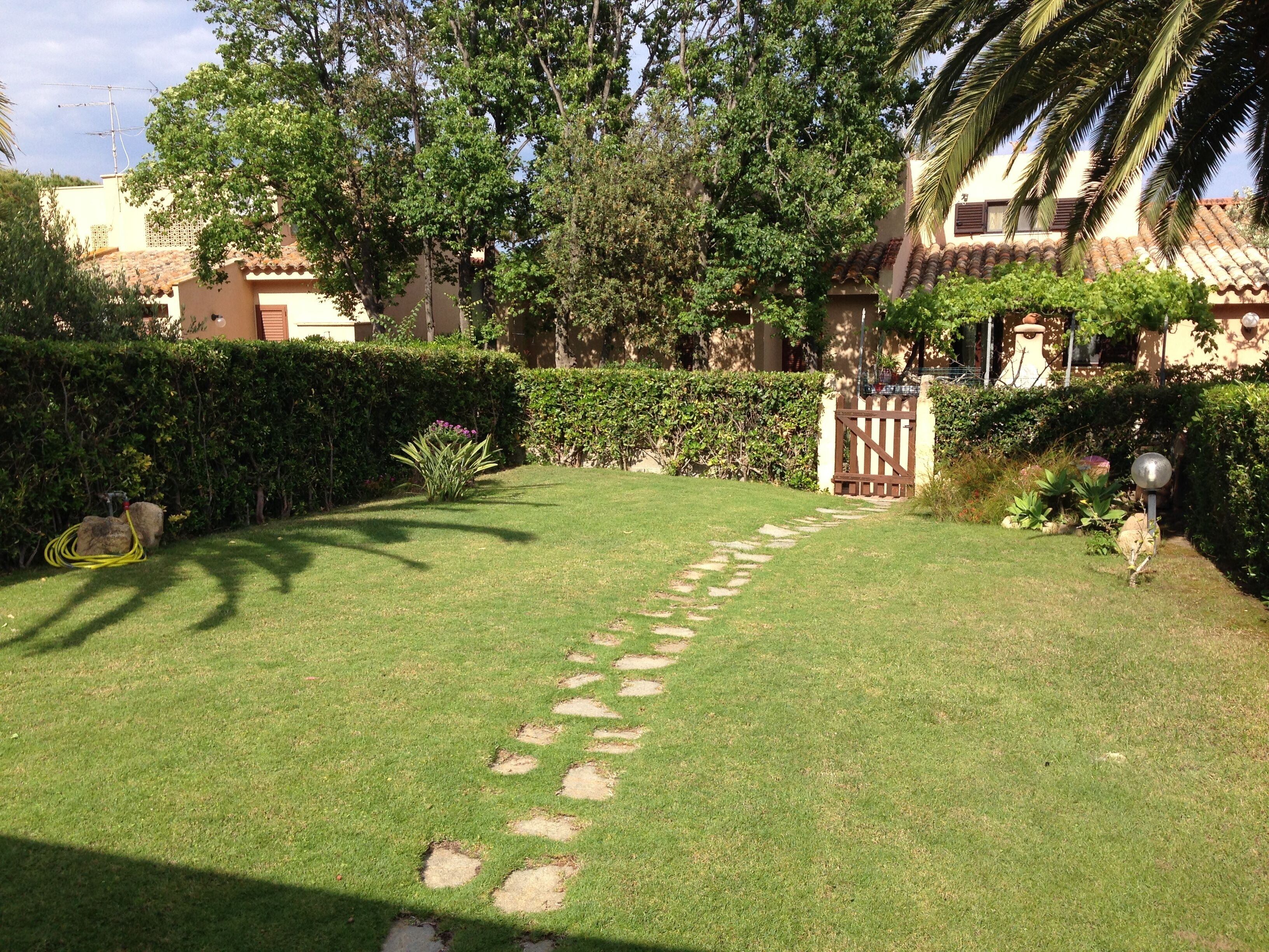 Un jardín bien cuidado con un camino despejado que lleva a una entrada con portón.