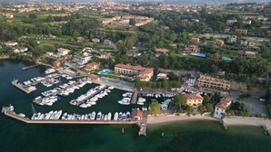 Vue aérienne d’une marina où sont amarrés des bateaux, entourée de bâtiments résidentiels et de verdure.