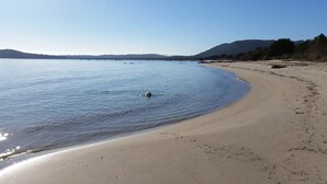 A beach with calm water, a sandy shore, and distant hills. - VERY QUIET SPACIOUS VILLA, SEA AND MOUNTAIN VIEWS, 500M FROM THE BEACH (Zonza)