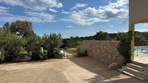 A courtyard with a pool, stone wall, and surrounding greenery. - VERY QUIET SPACIOUS VILLA, SEA AND MOUNTAIN VIEWS, 500M FROM THE BEACH (Zonza)