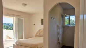 A bedroom with a bed, a bathroom with a shower, and a balcony with a view of the hills. - VERY QUIET SPACIOUS VILLA, SEA AND MOUNTAIN VIEWS, 500M FROM THE BEACH (Zonza)