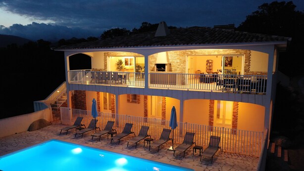 A two-story building with a swimming pool, lounge chairs, and a balcony with outdoor seating. - VERY QUIET SPACIOUS VILLA, SEA AND MOUNTAIN VIEWS, 500M FROM THE BEACH (Zonza)