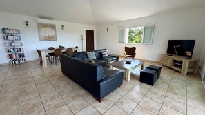 A living room with a sectional sofa, a coffee table, a TV stand, and a bookshelf. - VERY QUIET SPACIOUS VILLA, SEA AND MOUNTAIN VIEWS, 500M FROM THE BEACH (Zonza)