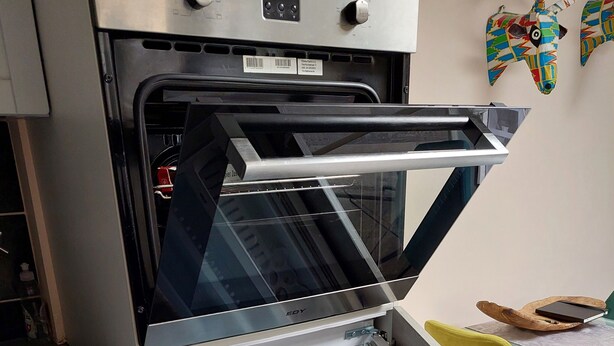 Une cuisine moderne équipée d’un réfrigérateur ouvert, d’un four à micro-ondes et d’un grille-pain.