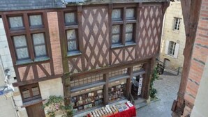 A traditional half-timbered building with a ground-floor shop displaying books.
