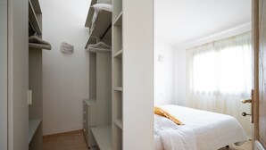 Une chambre à coucher avec un lit, une armoire et une fenêtre avec des rideaux.