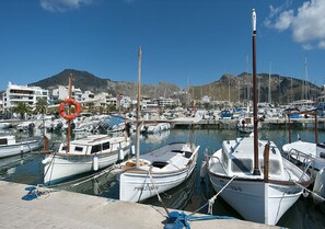 A marina with boats docked, a lifebuoy, and buildings in the background.