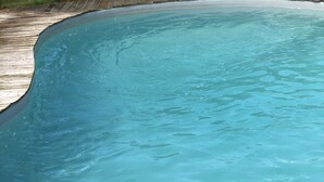A swimming pool with clear water and a wooden deck surrounding it. - renting a beautiful villa in the moors (Lahosse)