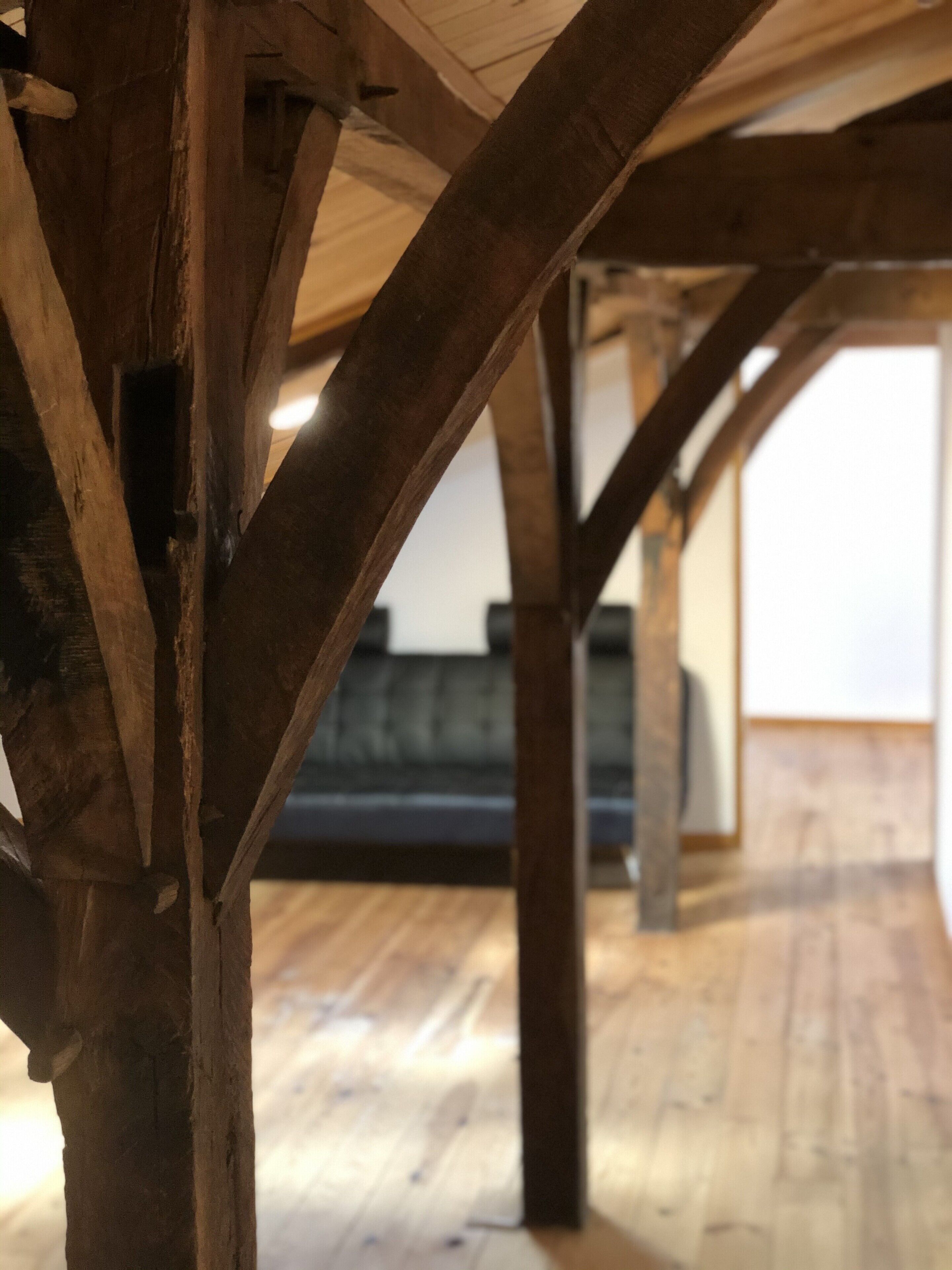 Estructura de techo de madera con vigas a la vista y piso de madera.