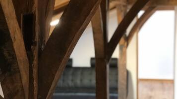 Estructura de techo de madera con vigas a la vista y piso de madera.