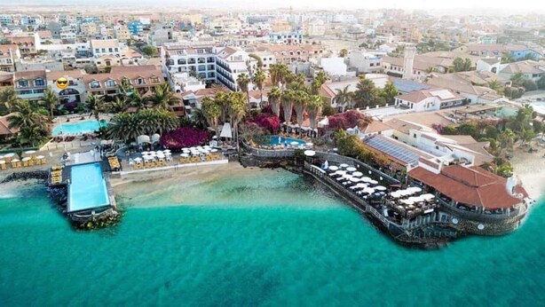An aerial view of a coastal resort with a pool, beach, and multiple buildings. - Apt71 Porto Antigo 2 Two Bed Penthouse with Shared Pool and Panaromic Sea Views. (Santa Maria)