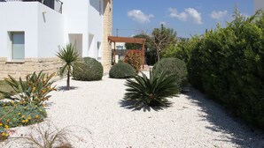 Un edificio moderno con fachada blanca, base de piedra y un balcón.