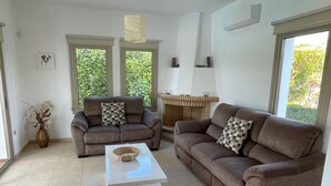 A living room with two brown sofas, a white coffee table, and a fireplace.