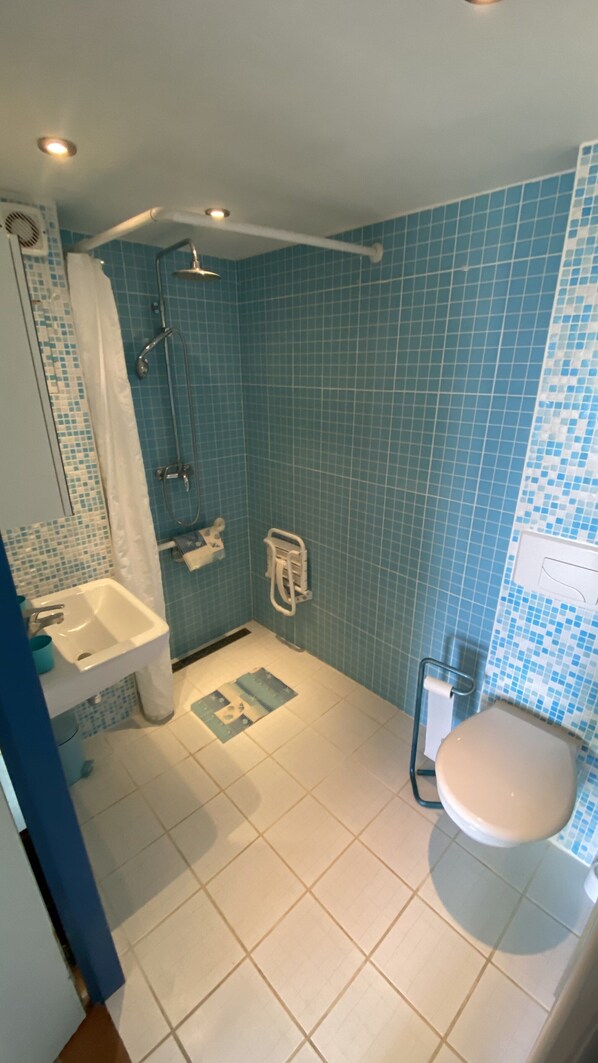 A bathroom with a shower, sink, and toilet.