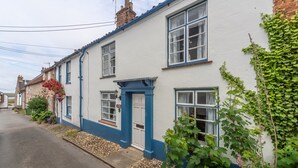A traditional white building with blue trim, a visible door, and windows. - Algerine Cottage,  Wells-next-the-Sea, Norfolk (Wells-next-the-Sea)