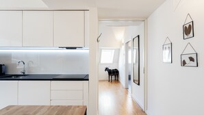 Una cucina moderna con mobili bianchi e un tavolo in legno.