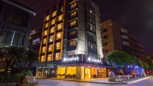 A multi-story hotel with illuminated signage and a ground-level restaurant.