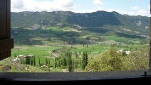 A view of a mountainous landscape with green fields and a few buildings. - Marquet house for 4 people (Valle de Lierp)