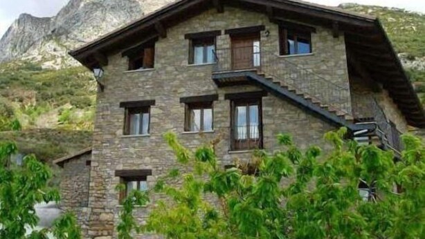 A stone building with multiple windows and a staircase. - Marquet house for 4 people (Valle de Lierp)