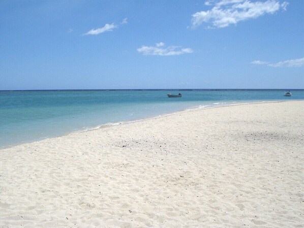 A beach with clear turquoise water and a sandy shore.
