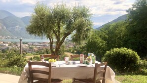 An outdoor table set with a view of a lake and mountains.