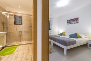 Regadera, secadora de cabello, pantuflas, toallas 