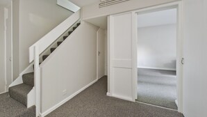 A staircase leading to a second floor, a closet with a sliding door, and a carpeted floor. - Spacious Notting Hill Flat (London)