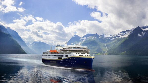 A cruise ship named "HAVILA KYSTRUTEN" sailing on a calm lake with mountainous landscape in the background. - Panoramic view, 50 m to lake, close to Sognefjord (Hemsedal)
