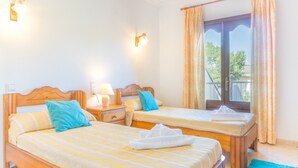 A hotel room with two single beds, a balcony, and a view of the outdoors. - Apartamento cerca de la playa Can Berenguer (Port d´Alcudia)