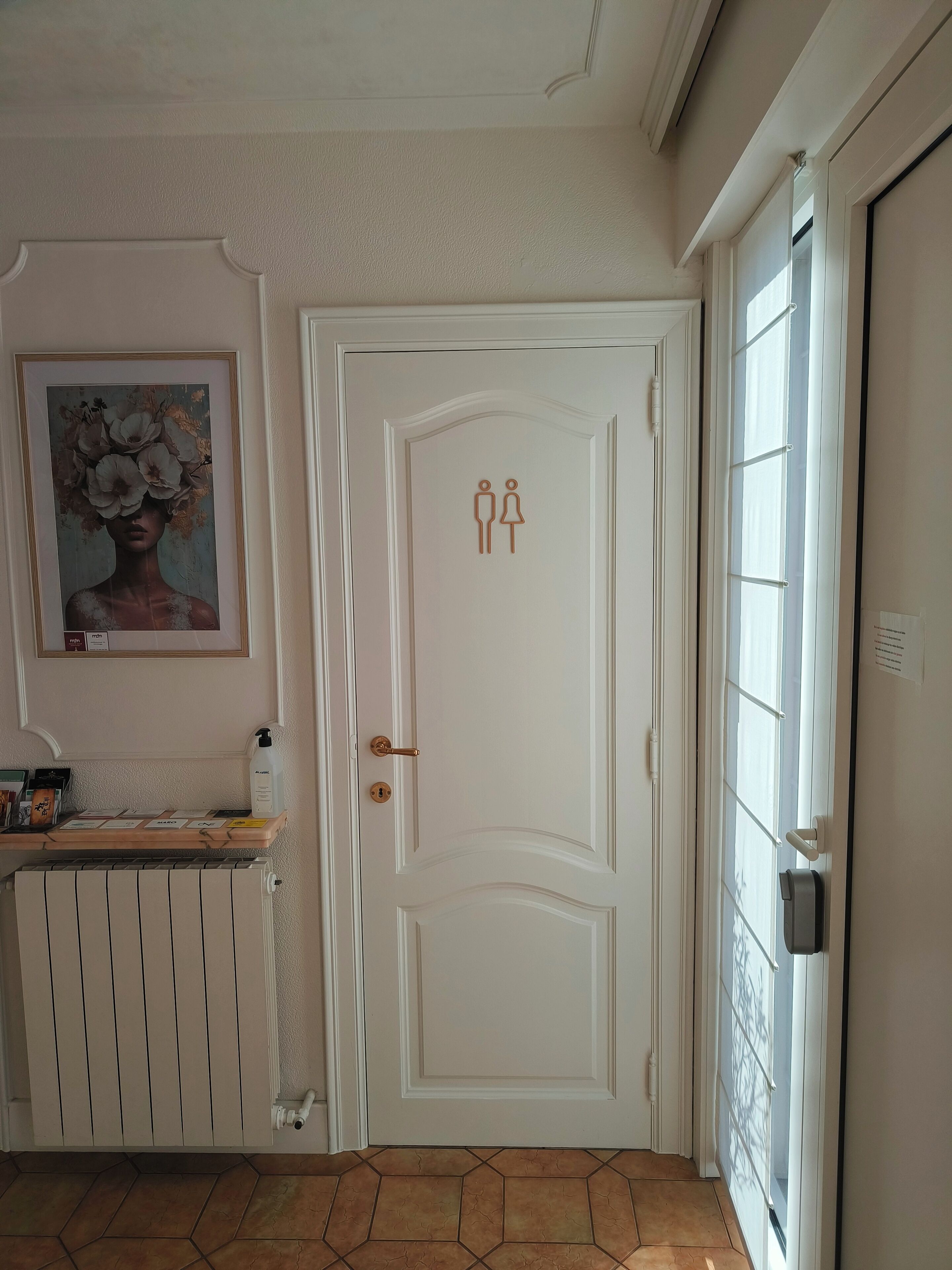 Een witte deur met een sleutelgat en een klein plankje met toiletartikelen.