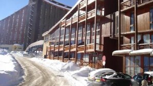 A multi-story building with balconies, a ski lift in the background, and a snow-covered ground. - Apartment/ flat - LES ARCS 2000 (Bourg-Saint-Maurice)