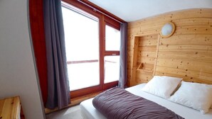 A bedroom with a bed, a window, and a wooden headboard. - Apartment/ flat - LES ARCS 2000 (Bourg-Saint-Maurice)