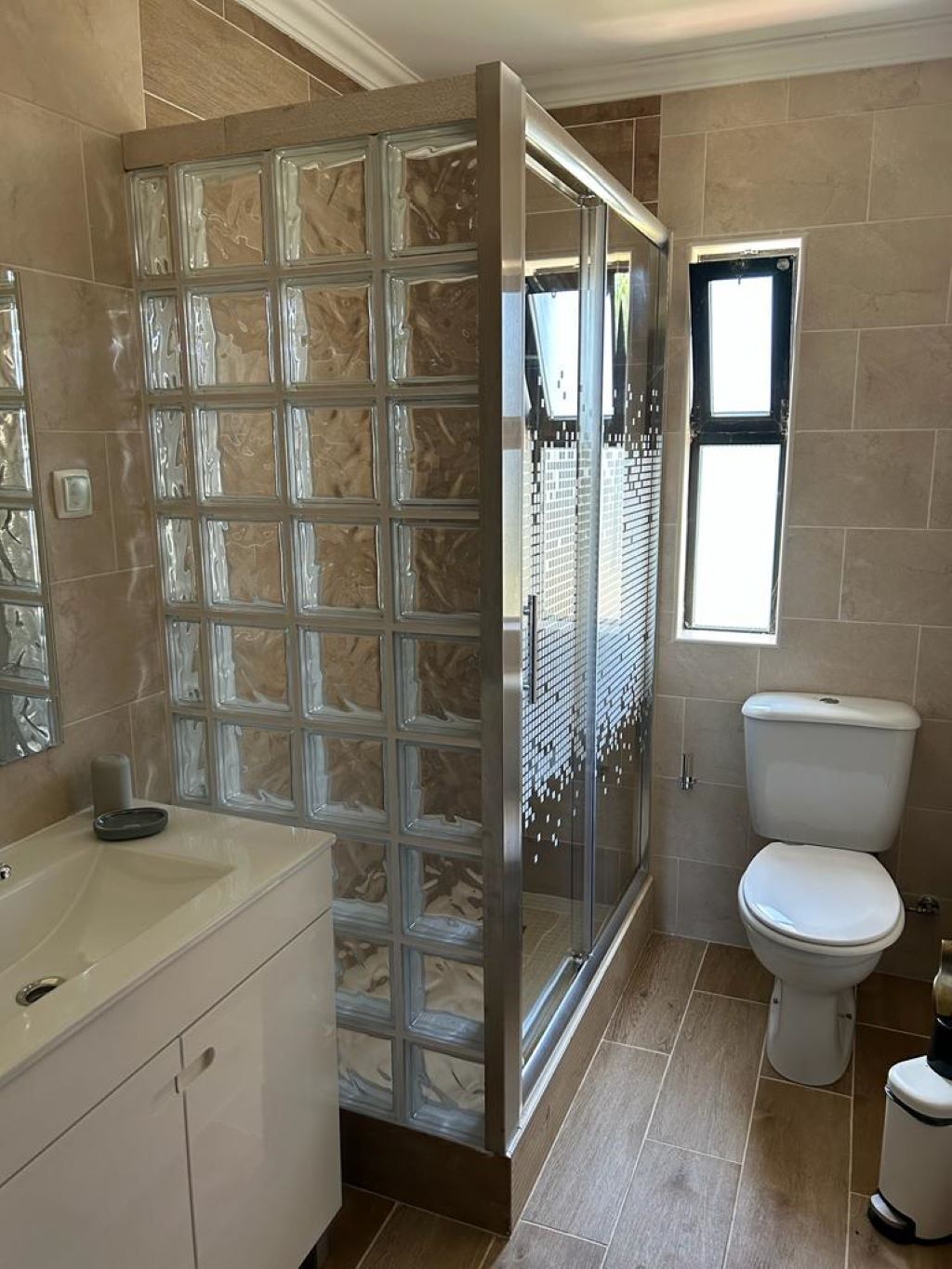 Ein Badezimmer mit Duschkabine, Toilette und Waschbecken.