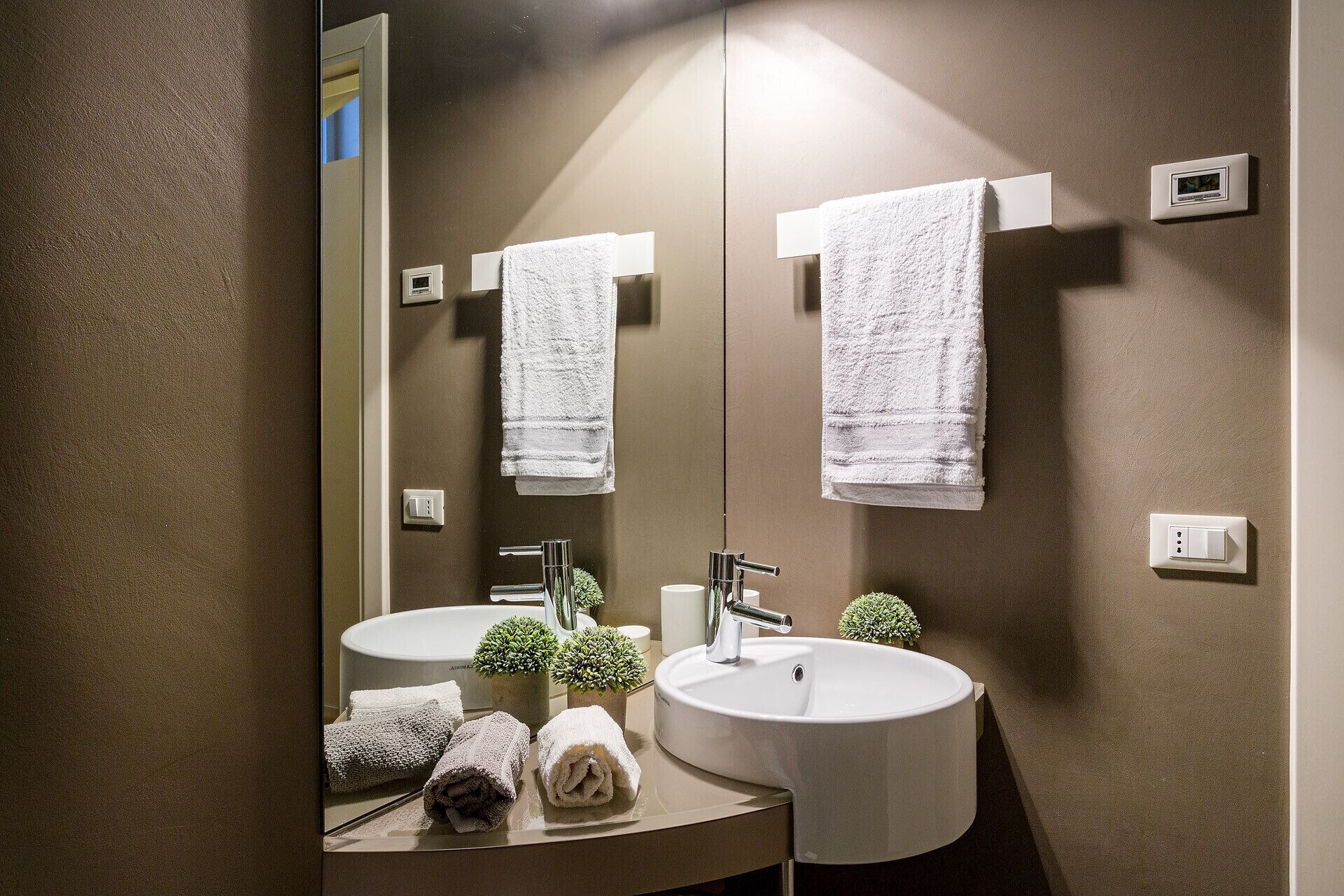 Ein Badezimmer mit zwei Waschbecken, einem Spiegel und Handtüchern.