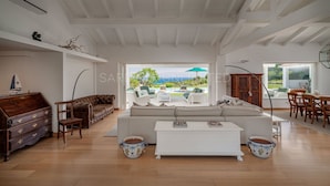 Un salon spacieux avec un grand canapé, une table basse et une vue sur l’extérieur.