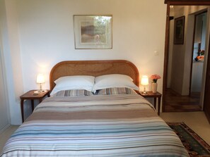 A neatly made bed with striped bedding, two bedside lamps, and a framed picture on the wall. - Charming Country Cottage With Large Heated Pool In Monbazillac, near Bergerac (Monbazillac)