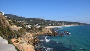 Une ville côtière aux bâtiments blancs, avec un littoral rocheux et une mer d’un bleu limpide.