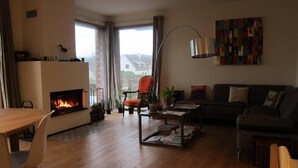 A living room with a fireplace, a sofa, a dining table, and a coffee table.