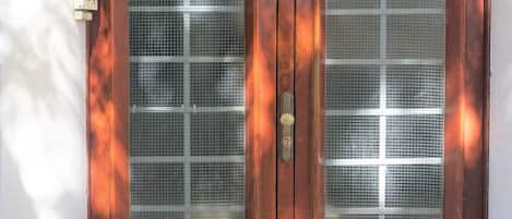 A secure entrance with a mesh screen and a discreet wall-mounted feature.