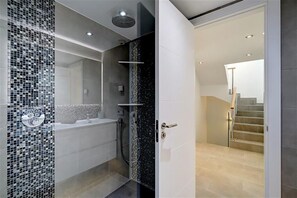 Ein modernes Badezimmer mit einer Wand aus Mosaikfliesen, einer Badewanne und einer Dusche.