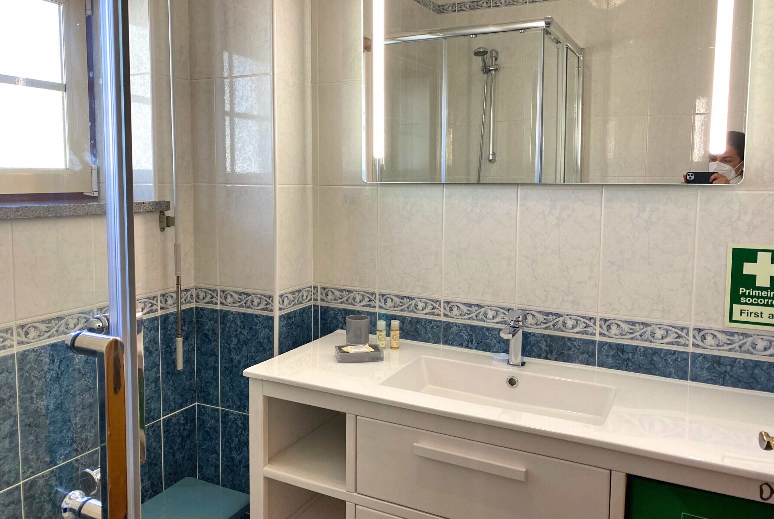 Ein Badezimmer mit Dusche, Waschbecken und einem Waschtisch mit Schubladen.