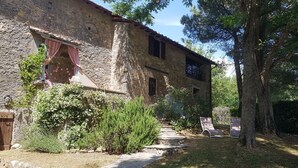 Un edificio rústico de piedra con un camino de piedra que conduce a una puerta de madera.