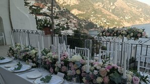 A table set for a meal with a view of a mountainous coastline.