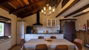 Un coin repas comprenant une table, des chaises et un lustre.