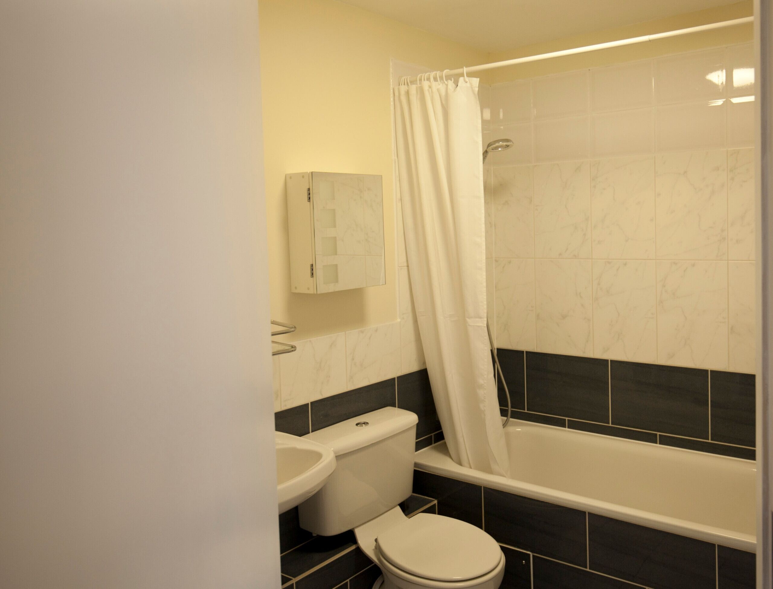 A bathroom with a bathtub, toilet, and sink.