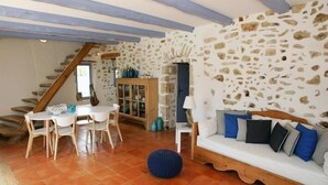 A rustic interior with a stone wall, wooden furniture, and a staircase. - SUPERB AIR-CONDITIONED STONE GITE, HEATED SWIMMING POOL, NEAR THE VALLON CENTER (Vallon-Pont-D'arc)