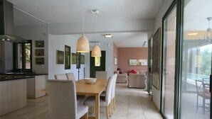 Una cocina moderna con comedor, ventanas amplias y vistas al exterior.