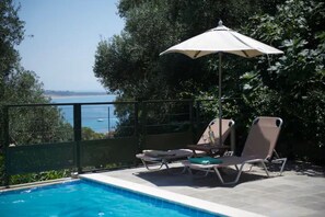 Una piscina al aire libre, tumbonas